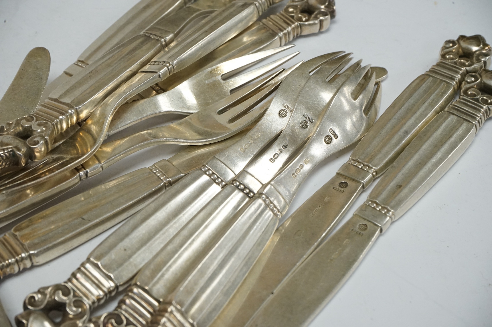 Ten George V Georg Jensen sterling acorn pattern dessert knives and nine matching forks, import marks for George Stockwell, London, 1931, 21.2oz. Condition poor to fair